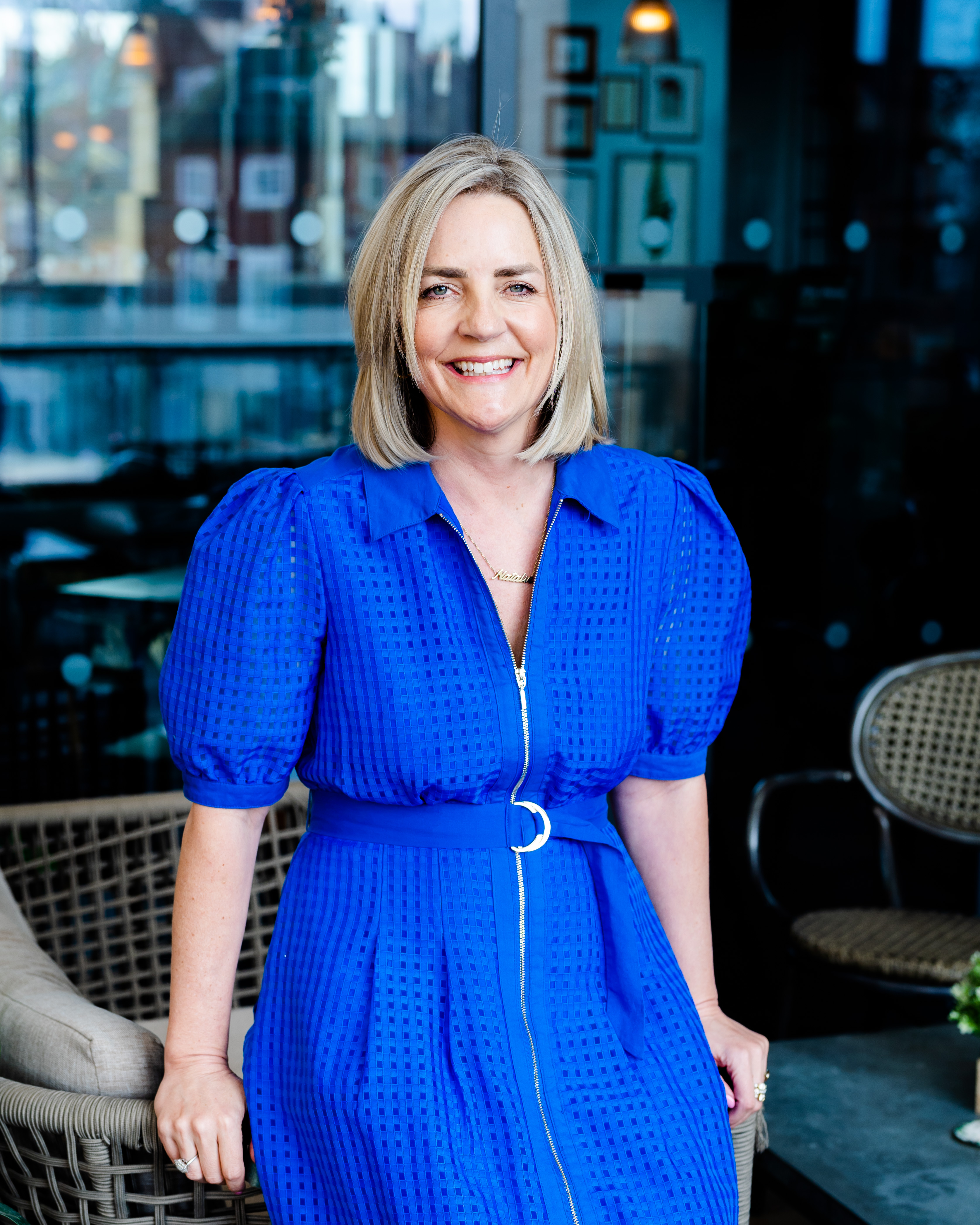 Natalie Heeley standing confidently in a blue dress
